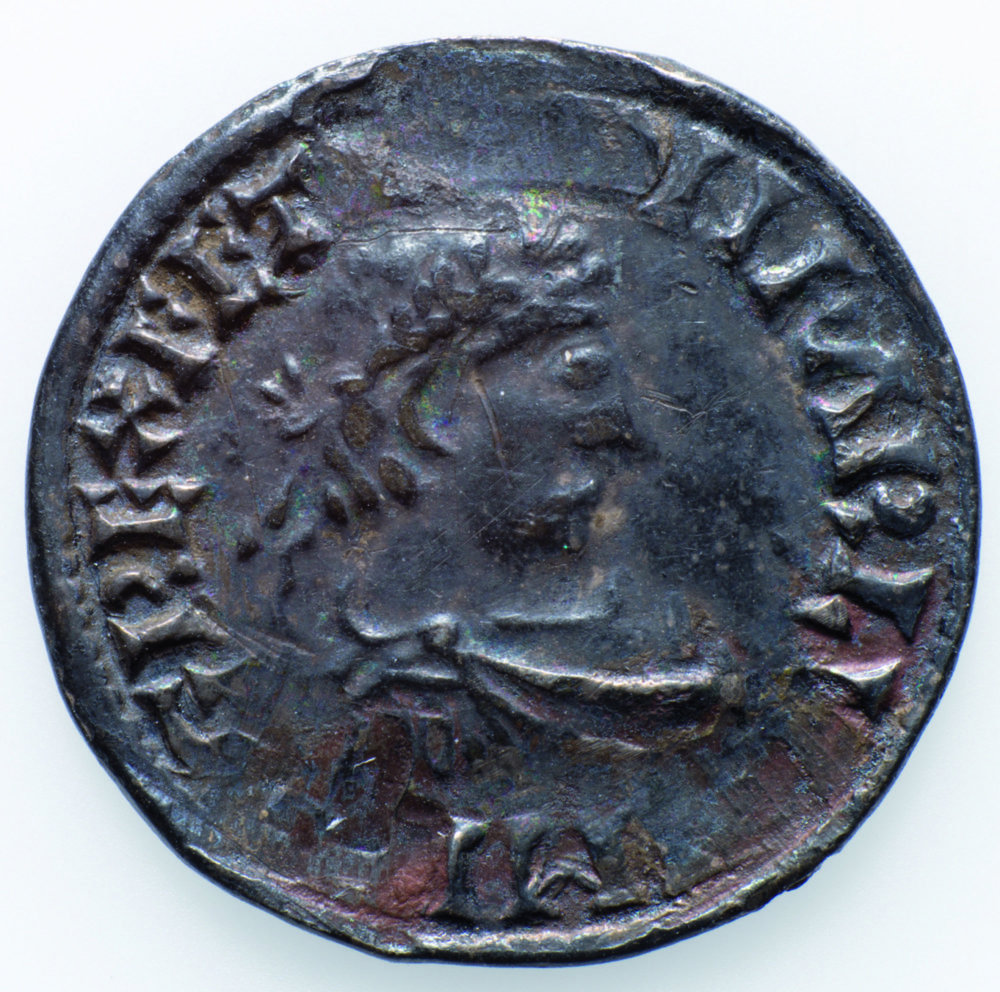 Karl den store-mynten fra Frosta (forsiden). Mynten er en denar, preget ca. 805–814, muligens i Milano eller Padova. Her ser vi portrettet av keiseren med laurbærkrans, etter romersk mønster. Foto: Åge Hojem, NTNU Vitenskapsmuseet