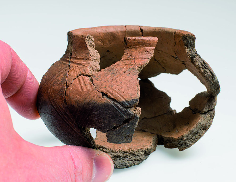 Dekorert kopp av keramikk, T 27079-2, funnet sammen med T 27079-1 i et av stolpehullene til Hus 34 på Felt C. Foto: Åge Hojem, NTNU Vitenskapsmuseet
