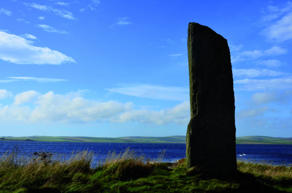  The Watchstone – «vaktsteinen» står ved brua mellom innsjøene Stenness og Harray. I dag i ensom givakt, for mange tusen år siden en av mange bautaer i prosesjonsveien mellom steinsirklene i et stort rituelt og hellig landskap. Foto: Kristin Prestvold 