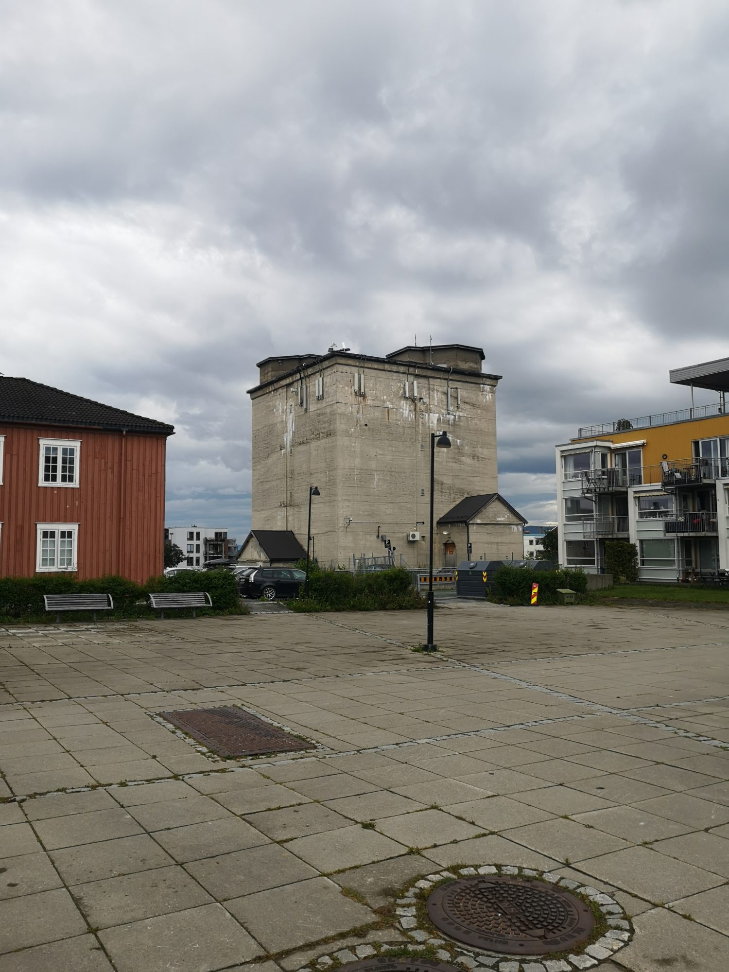 Lager- og tilfluktsbunker med plattform for luftvernkanoner på toppen. Til venstre ligger et av forlegningshusene, til høyre ligger en nyoppført
boligblokk. Foto: Kristoffer E. Grini