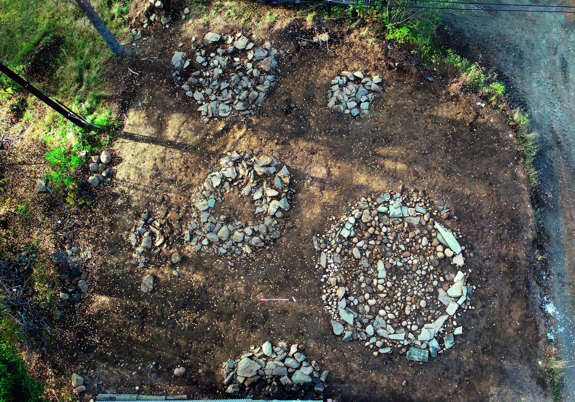 Gravformene i førromersk jernalder og eldre romertid likner hverandre, og har form av enkle steinsirkler og steinlegninger. Grønnsteinssirkelen lengst til høyre i bildet. Foto: Roger Skjelbakken, NTNU Vitenskapsmuseet. 
