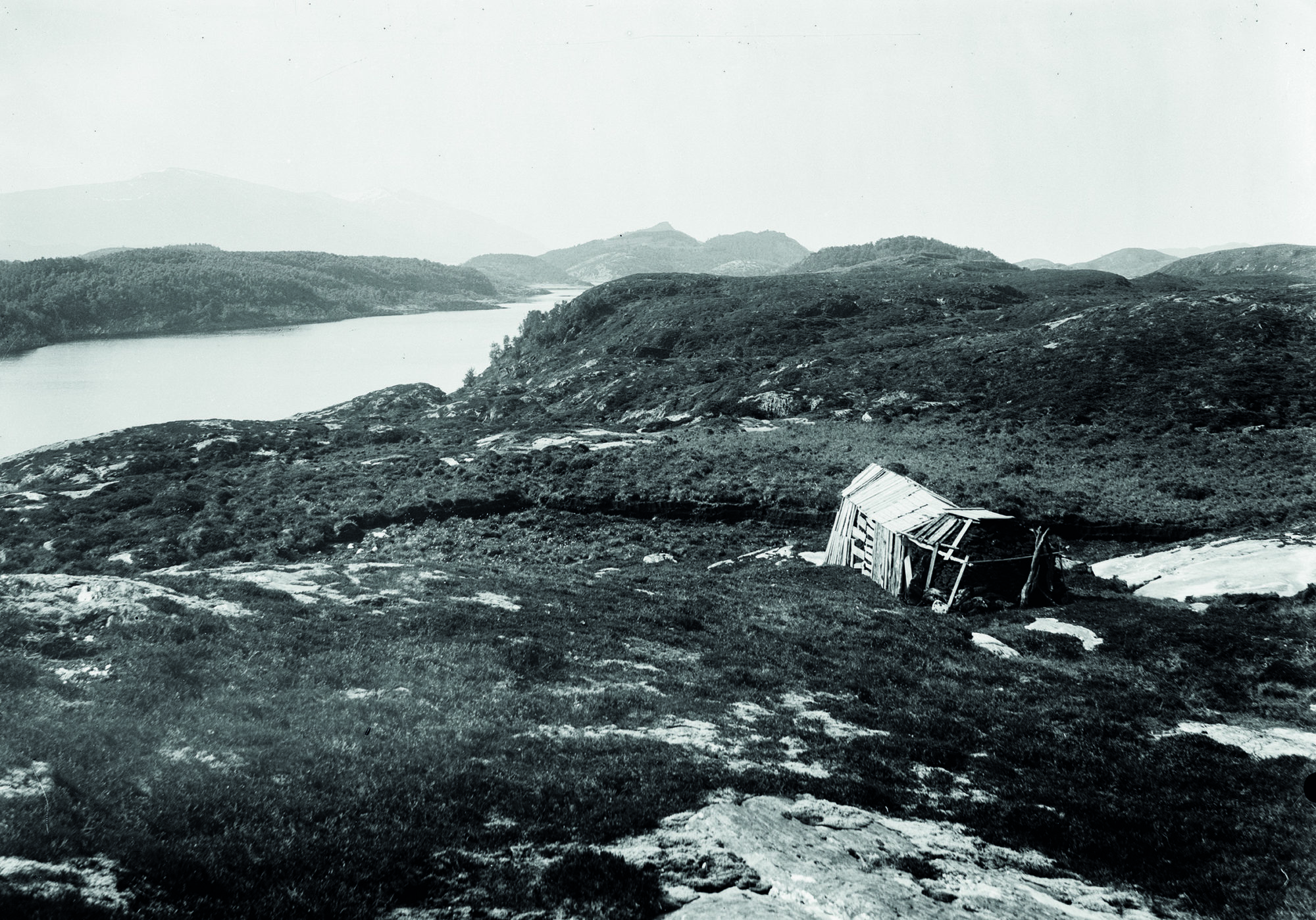 Utsikt mot bergkunstfeltet og fjorden. Feltet ligger til høyre for skuret. Foto: Gutorm Gjessing 1933