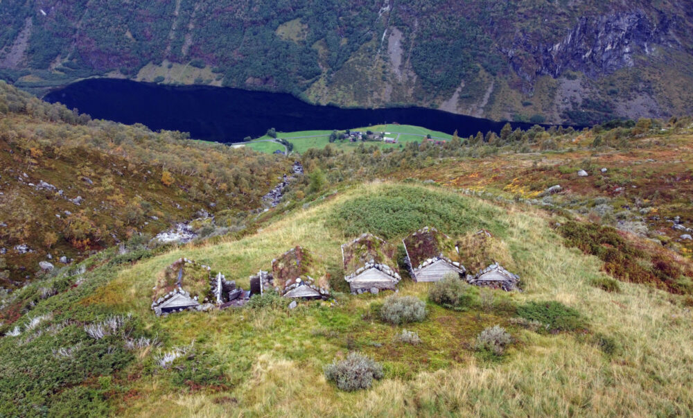 Fem små hus høyt over en fjord